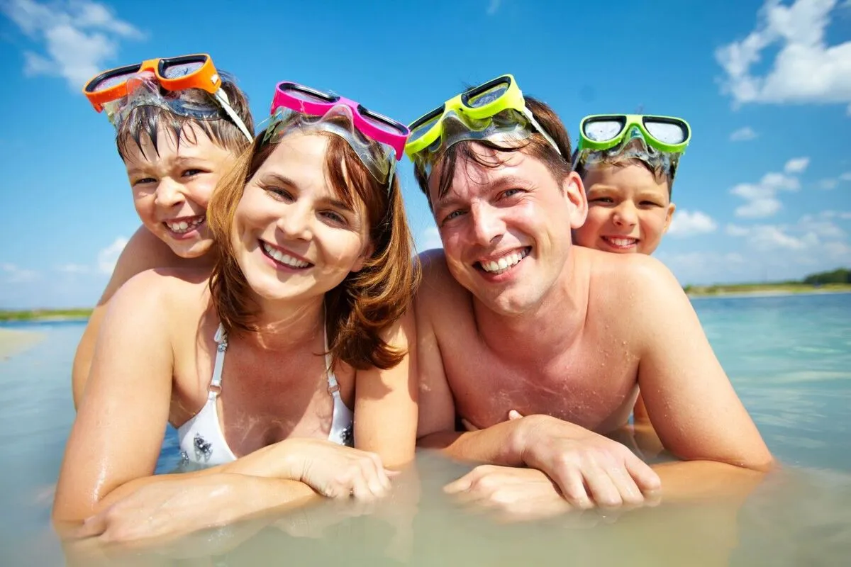 familie cu doi copii, în apă, cu ochelari pentru înot