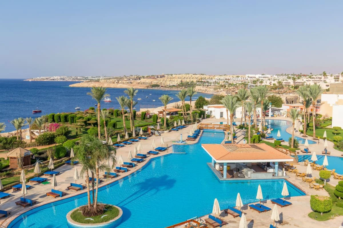 resort in Sharm El-Sheikh, cu piscina si palmieri, iar pe fundal se vad orasul si marea
